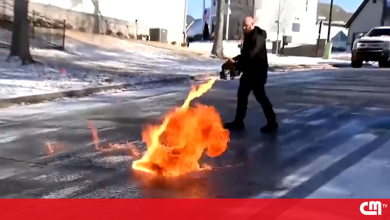 Os homens usam o jato de chama derretendo o gelo no vídeo da estrada